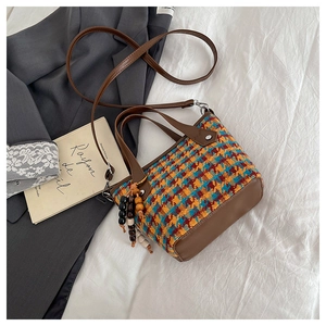 Détail du sac cabas à carreaux avec perles en bois sur un fond de style français chic
