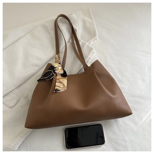Détail du sac cabas marron foncé orné d'un foulard en soie et surface en similicuir lisse