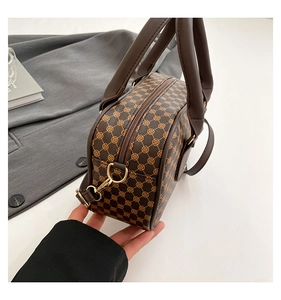 Macro view of vintage brown monogram handbag with premium leather texture and metal zipper