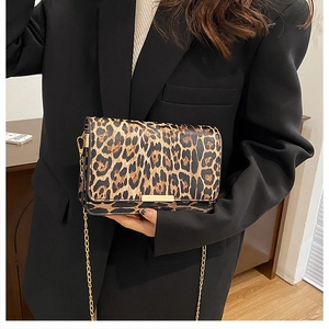 Detail of trendy leopard print shoulder bag with gold chain strap and metal clasp closure