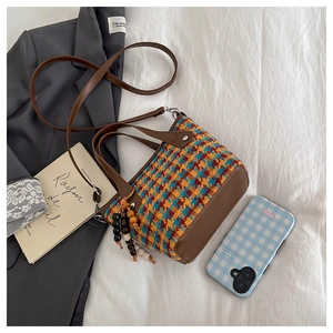 Détail d'un sac cabas vintage en tweed avec charms en perles de bois et bandoulière