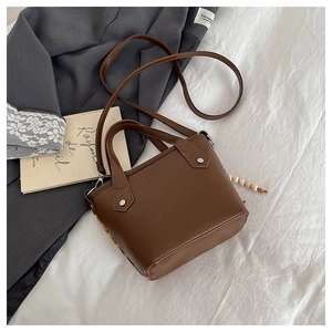 Détail d'un sac cabas en cuir PU marron avec patchwork ethnique et rivets argentés