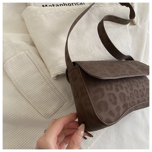 Close-up of vintage brown leopard print baguette bag with matte texture and flap closure