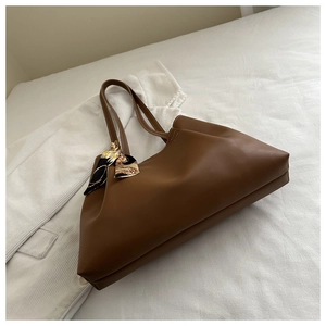 Gros plan détaillé d'un sac cabas marron caramel orné d'un élégant foulard en soie décoratif