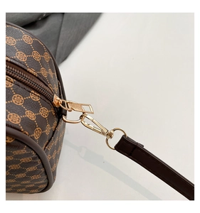 Detailed macro of brown floral shoulder bag featuring gold metal hooks and durable zipper