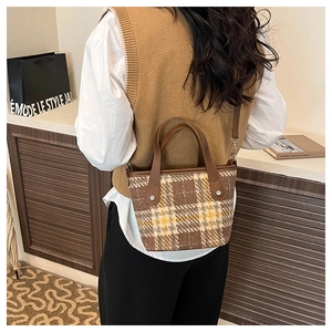Détail du sac cabas vintage à carreaux avec poignées en cuir et bandoulière réglable