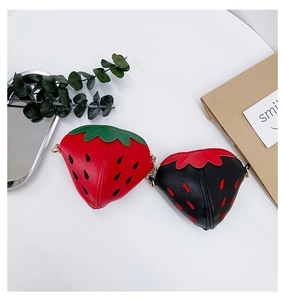 Dettaglio di mini borse a tracolla a forma di fragola in rosso e nero con catenella