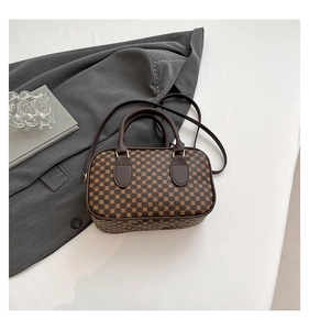 Top-down view of a retro geometric pattern Boston bag on a gray suit with gold hardware