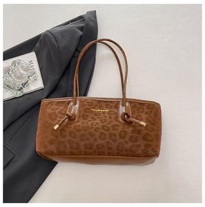Macro detail of leopard print tote bag with gold lettering and smooth leather texture