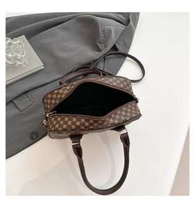 Detail view of the spacious interior and brown monogram pattern on the square handbag