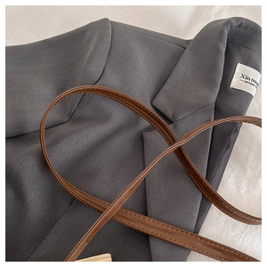 Détail du sac cabas gris à carreaux avec étiquette de marque et anse en cuir