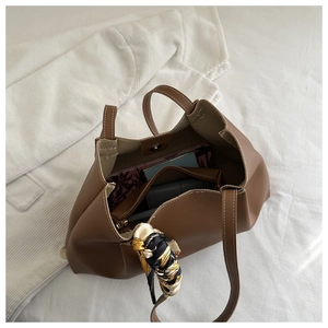 Détail d'un grand sac cabas marron avec surpiqûres blanches et foulard en soie décoratif