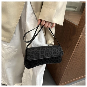 Detail of gray leopard print baguette bag with textured faux fur and slim shoulder strap