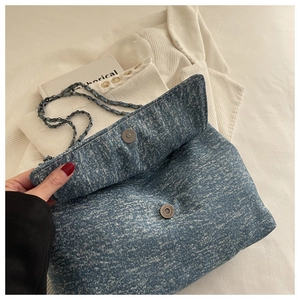 Vue détaillée du sac en jean bleu avec fermeture magnétique et bandoulière chaîne
