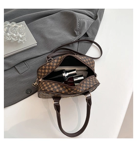 Spacious interior of brown monogram Boston bag showing storage for phone and perfume