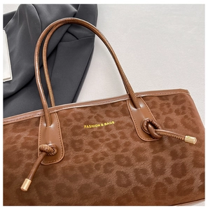 Macro detail of leopard print tote bag featuring velvet texture and tied leather handles