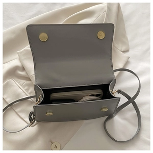 Interior view showing capacity of grey leather square bag with dual magnetic buckles