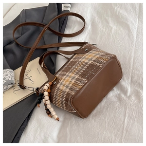 Détail du sac cabas en tweed à carreaux et cuir marron avec pendentif en perles