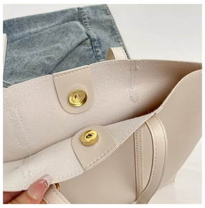 Close-up of the dual magnetic metal buckle and premium synthetic leather of the tote bag