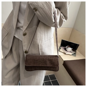 Detail of leopard print baguette bag on a beige blazer for a stylish fall look