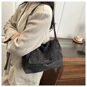 Détail du cabas en tweed gris foncé avec bandoulière chaîne et barre métallique