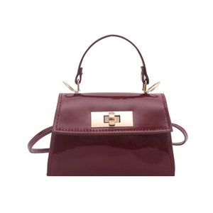 Mini wine red patent leather trapezoid handbag with gold metal clasp and crossbody strap