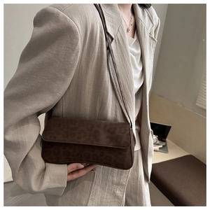 Detailed view of brown leopard print baguette bag with soft matte texture and slim strap