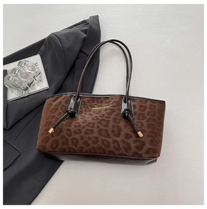 Close-up of leopard print tote bag fabric with leather strap and metal hardware details