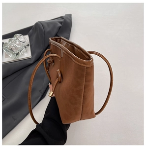 Side view of brown leopard tote bag with knotted shoulder strap and slim structured body