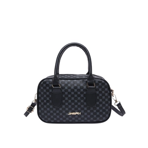 Vintage black Boston handbag with polka dot texture and gold hardware on white background