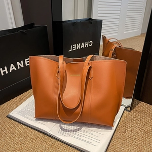 Minimalist large capacity tote bag in caramel brown leather with gold lettering detail