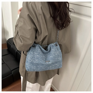 Détail du sac cabas en tweed bleu et blanc montrant la texture tissée et la bandoulière