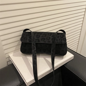 Vintage black leopard print baguette bag with velvet texture on a minimalist background