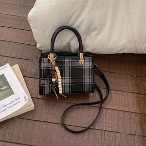 Retro plaid crossbody square bag with wood bead charm on dark wood floor background