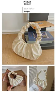 Detail der beigen gefalteten Dumpling-Tasche mit weichem Leder und elegantem Schulterriemen
