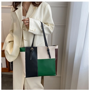 Detail of color-block PU leather tote bag with green, beige, and black panels