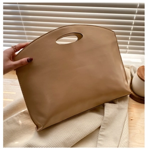 Detail of beige large capacity business envelope bag with cutout handle and fine stitching