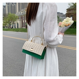 Détail du rabat tissé et du corps en cuir vert avec chaîne dorée sur le sac bandoulière