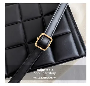 Détail du sac noir gaufré à carreaux avec bandoulière réglable et boucle dorée brillante