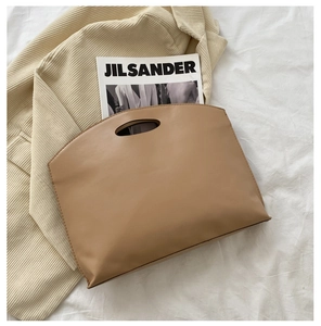 Detail of minimalist khaki brown tote bag with oval handle on velvet fabric