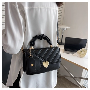 Quilted black PU leather bag with heart lock and matching coin purse shown on shoulder