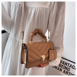 Detail of khaki PU leather bag with chevron quilting, heart buckle, and small coin purse