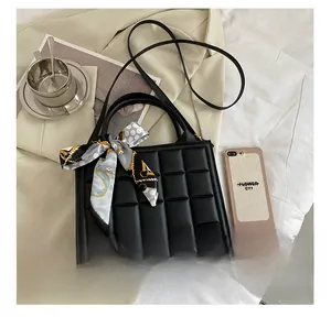 Détail du sac à bandoulière matelassé noir avec foulard en soie et comparaison de taille