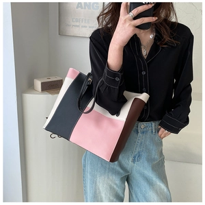 Detail view of large color-block tote bag in pink, white and black faux leather
