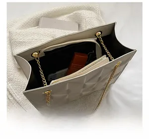 Détail de l'intérieur du grand sac cabas matelassé avec chaîne dorée et compartiments