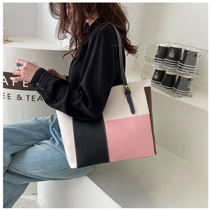 Outdoor lifestyle shot of a large color-block tote bag with adjustable shoulder strap