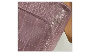 Detail showing neat stitching on a dark purple crocodile pattern leather shoulder bag