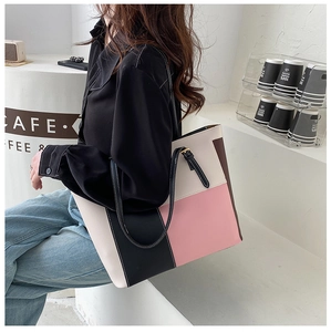 Close-up of color-block tote bag with adjustable shoulder strap and leather texture