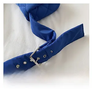 Détail de la bandoulière matelassée bleue en nylon avec boucle argentée et œillets renforcés