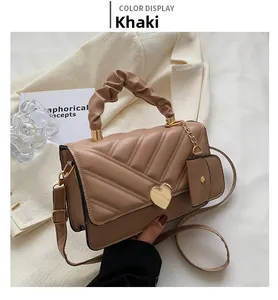 Detail of khaki PU leather bag with V-shaped quilting and golden heart-shaped twist lock